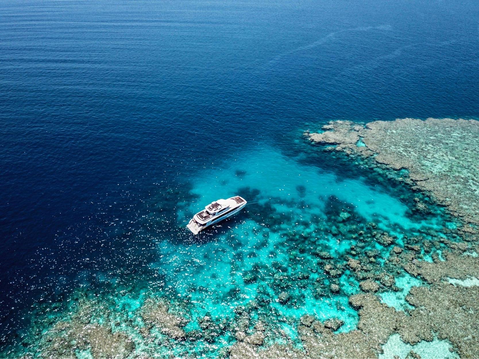 drink shot of a dive boat next to a coral reef