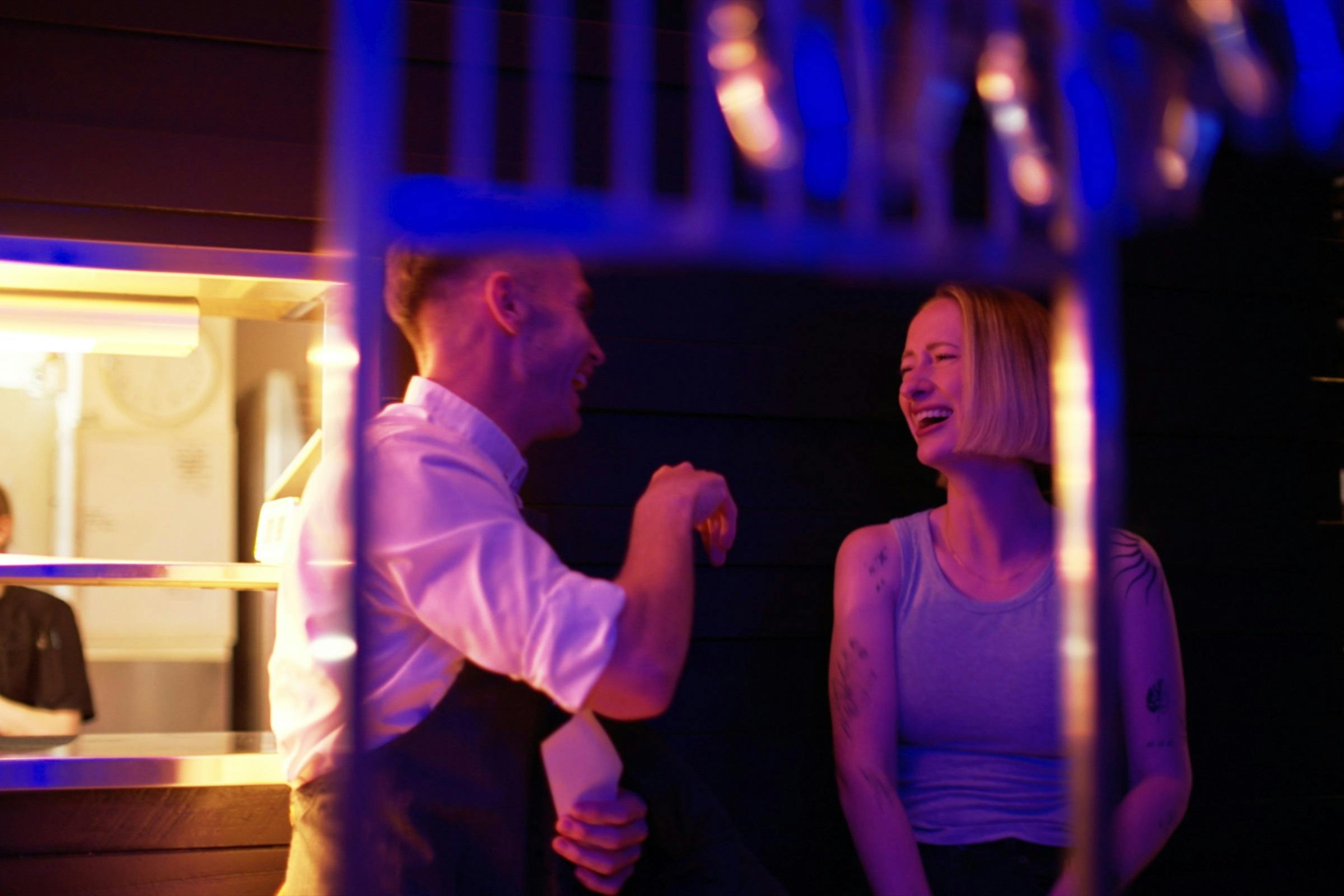 Staff member sharing a laugh with a guest at Mudbar Restaurant in Launceston