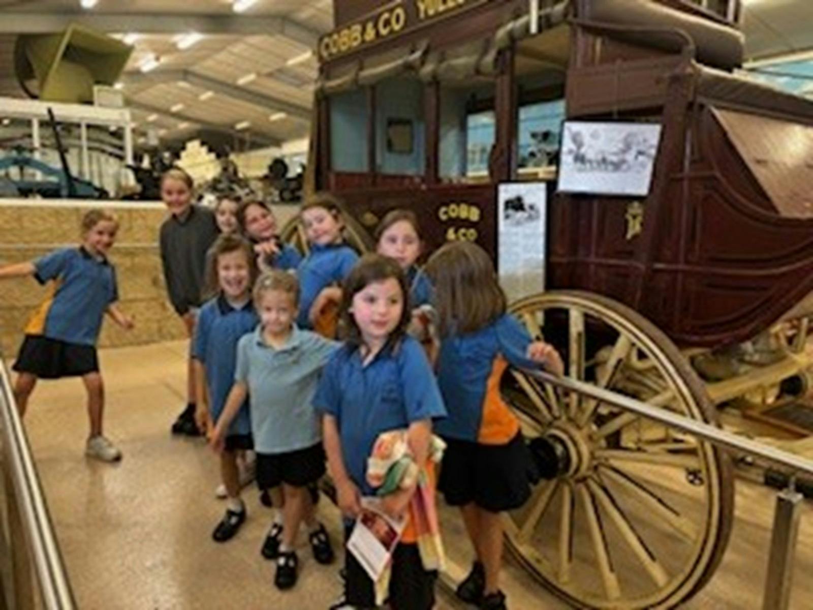 A group of children in front of a coach.