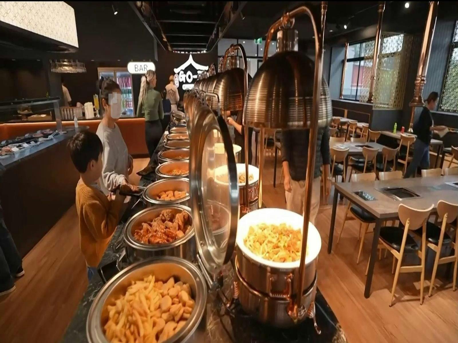 Hot buffet section with a variety of Korean dishes including fried chicken and tteokbokki. Hot buffet section with a variety of Korean dishes including fried chicken and tteokbokki.