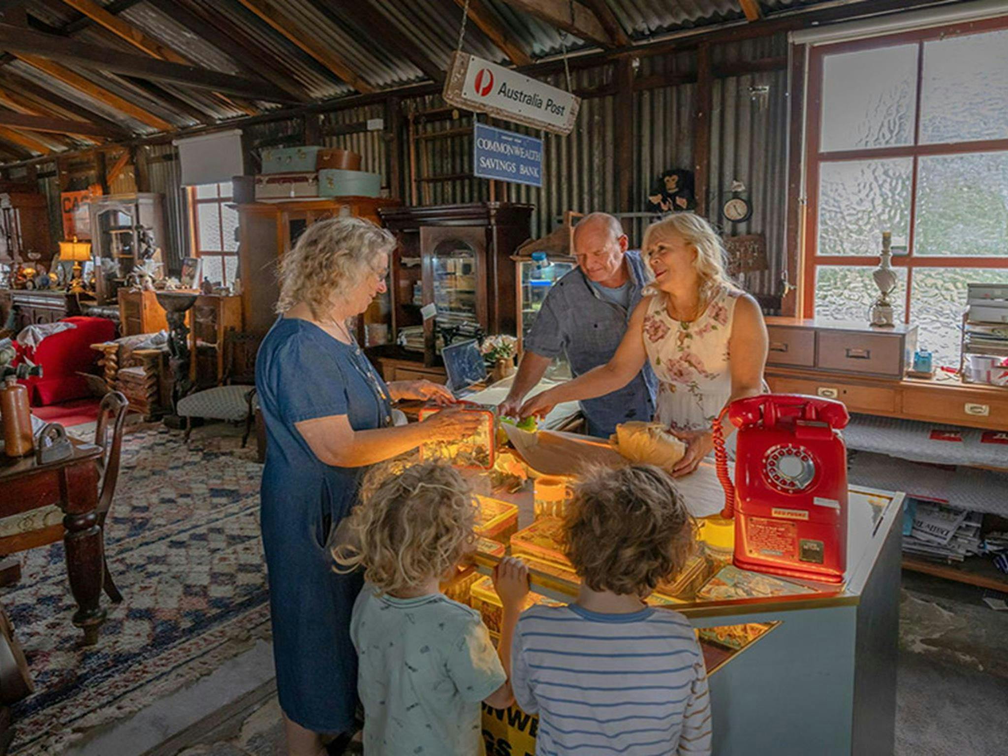 하틀리 역사 유적지의 옛 코니스 차고 내에 있는 골드 러시 앤틱스 카운터에서 쇼핑하는 사람들.