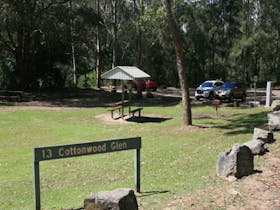 The grassy area at Cottonwood Glen picnic area with picnic shelter and carpark in the distance at