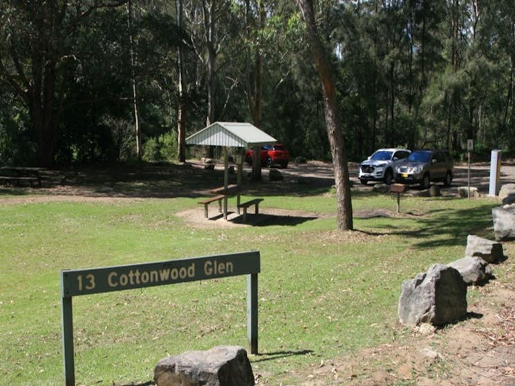 The grassy area at Cottonwood Glen picnic area with picnic shelter and carpark in the distance at