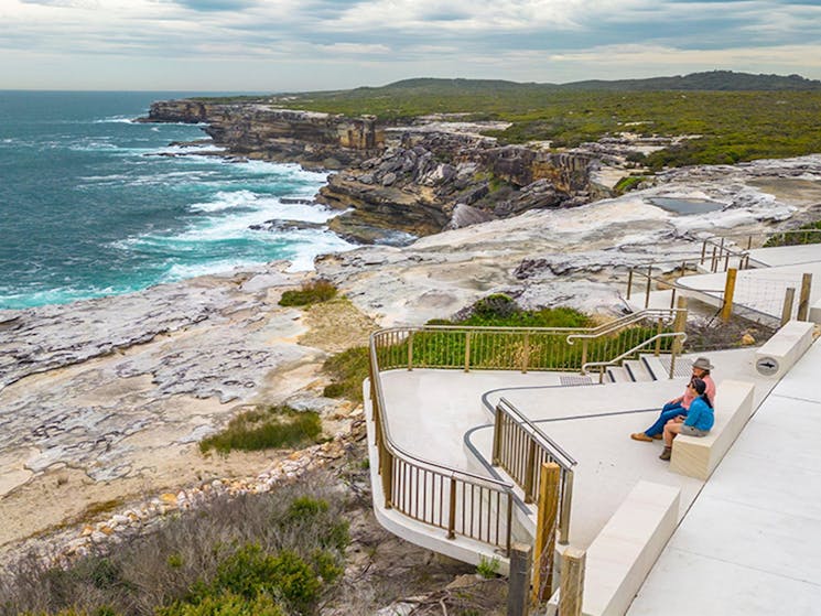 People looking out over the ocean from the whale watching platform at Cape Solander. Photo: John