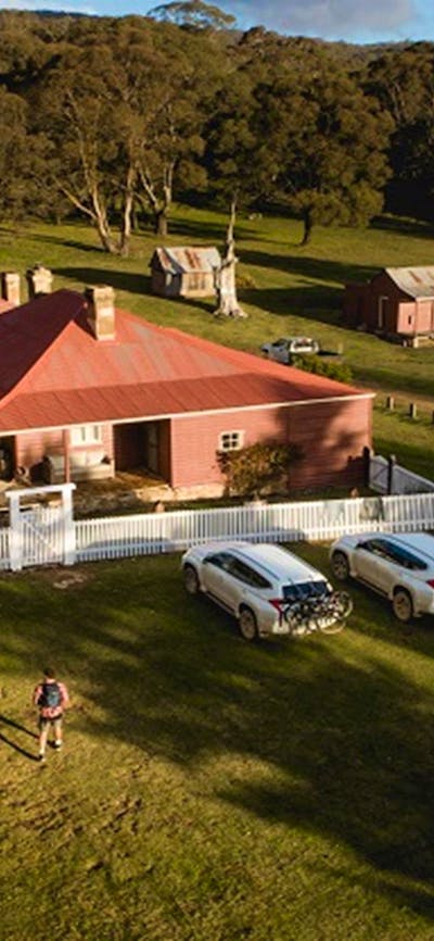 A bird's eye view of a couple walking towards Currango Homestead, Kosciuszko National Park. Photo: