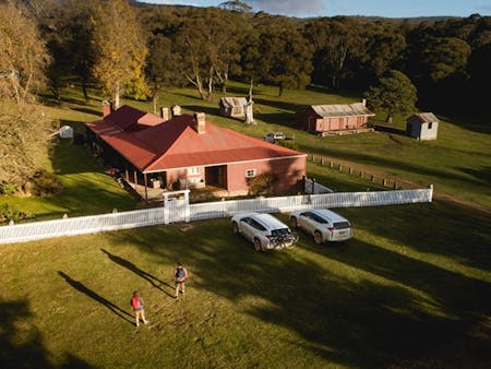 A bird's eye view of a couple walking towards Currango Homestead, Kosciuszko National Park. Photo: