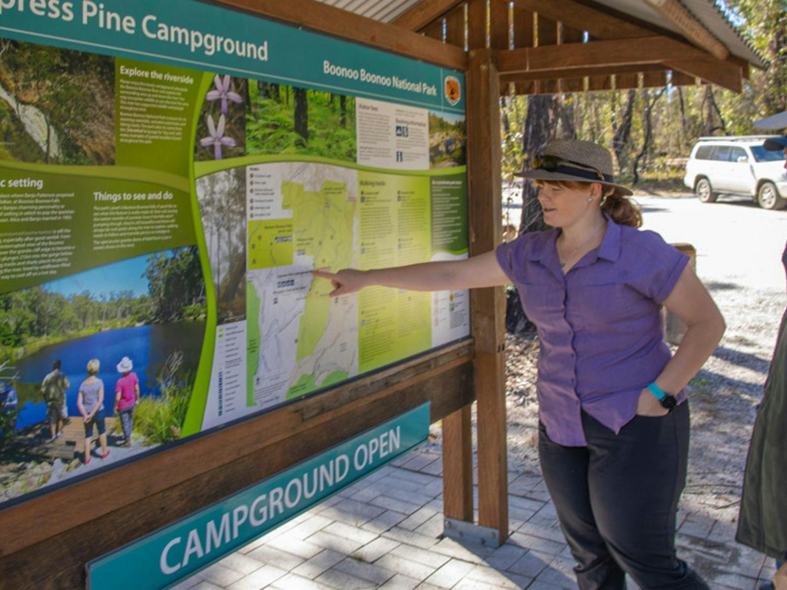 Visitors reading the Cypress Pine campground sign. Credit: Joshua J Smith © DPIE