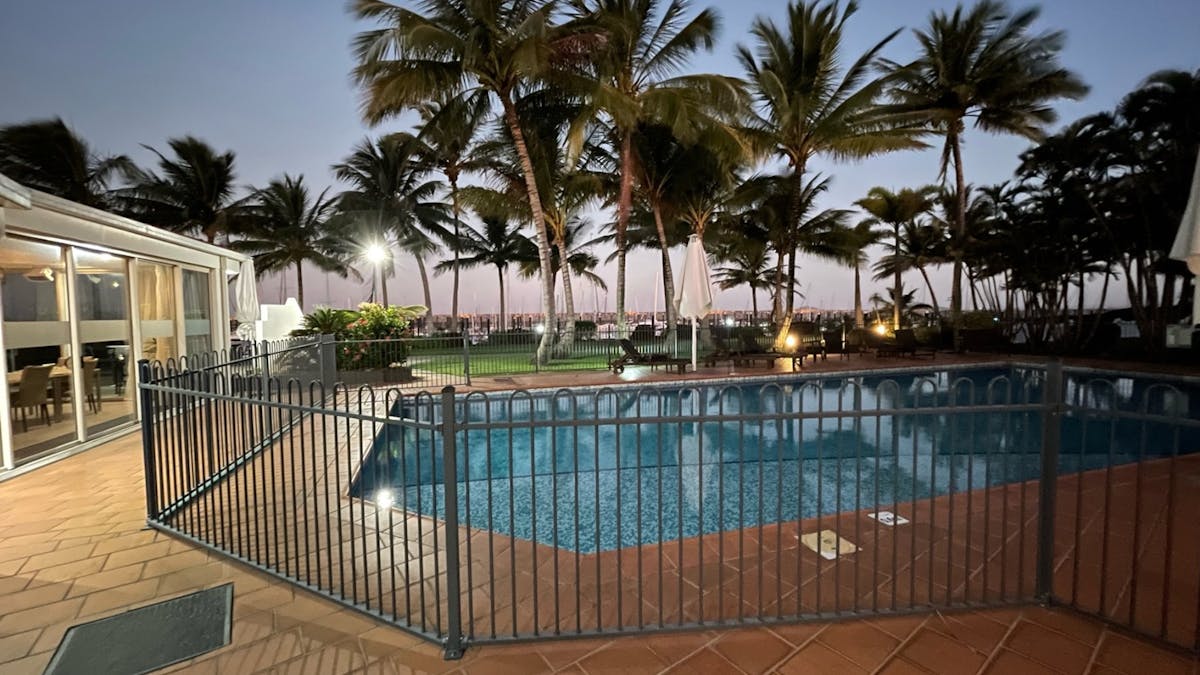 Mantra Mackay swimming pool at dusk beside the marina