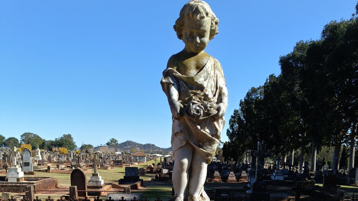 Stunning marble cherub memorial stands over a grave at the Drayton and Toowoomba Cemetery