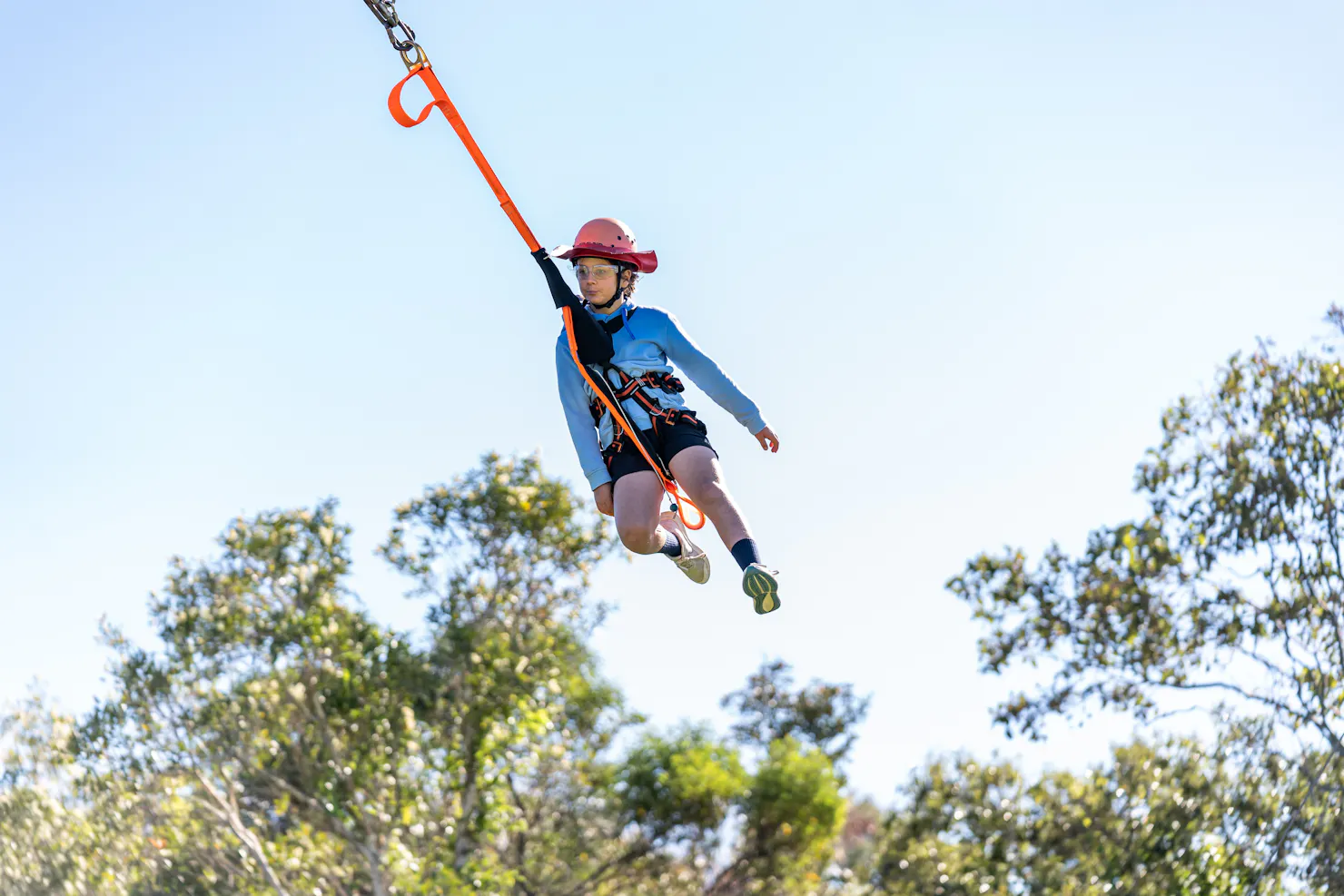 Child sailing through the air attached to the giant swing by a harness