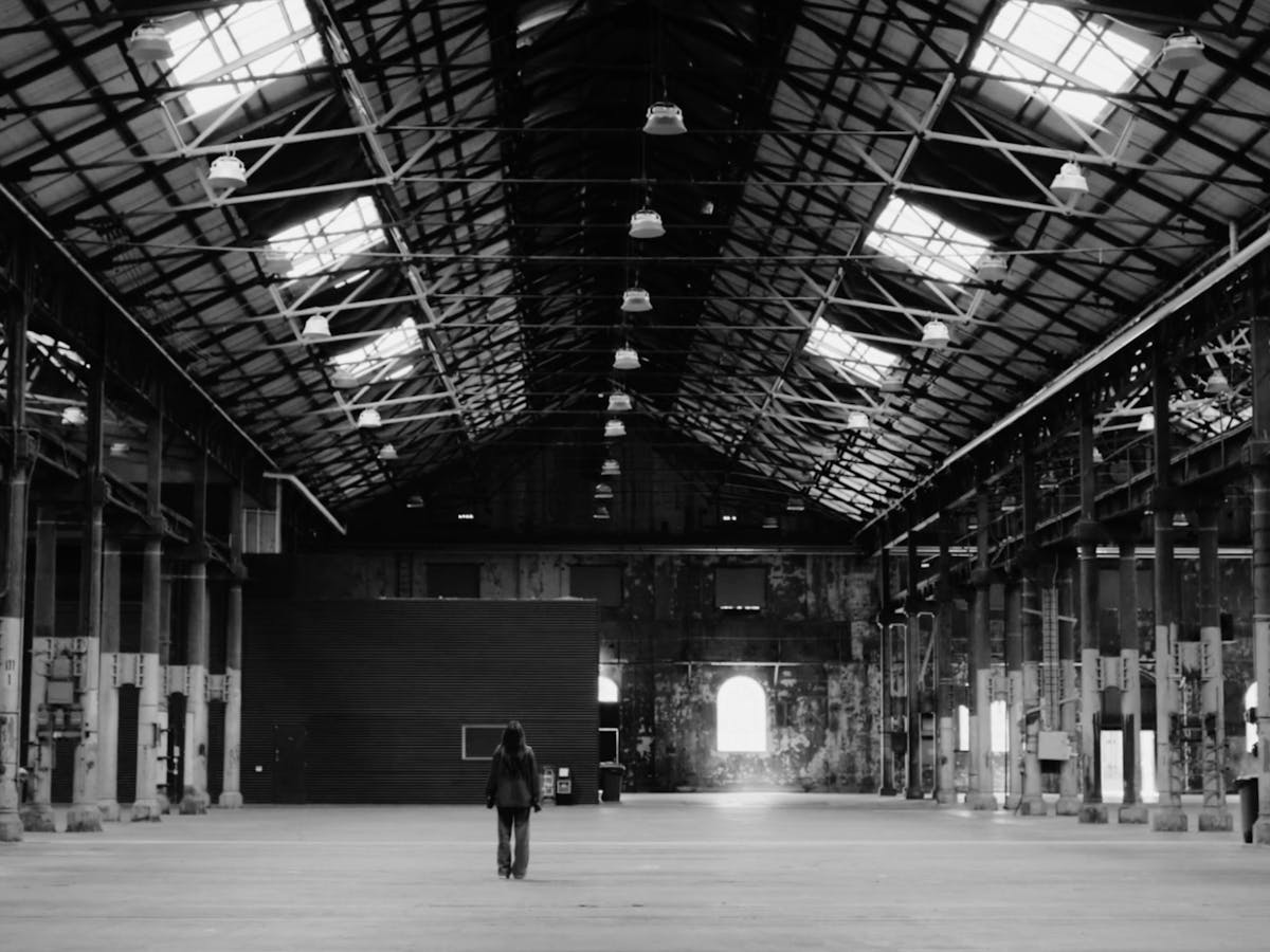 person standing in an empty warehouse space