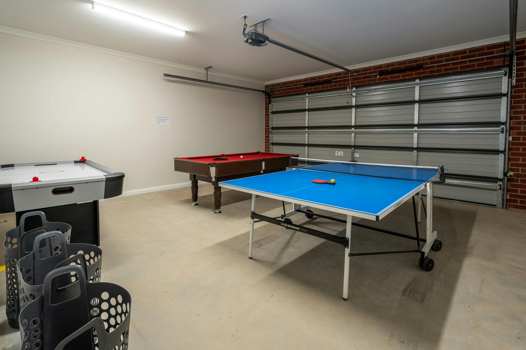 탁구대 당구대 에어하키 테이블을 갖춘 차고입니다.
