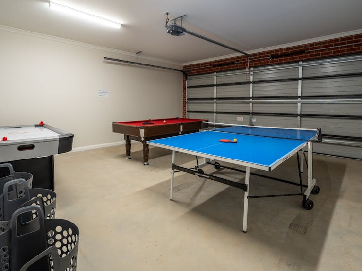 Garage featuring ping ping table, pool table and air hockey table.