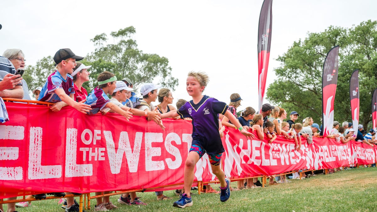 Kids running down finishing line giving high 5