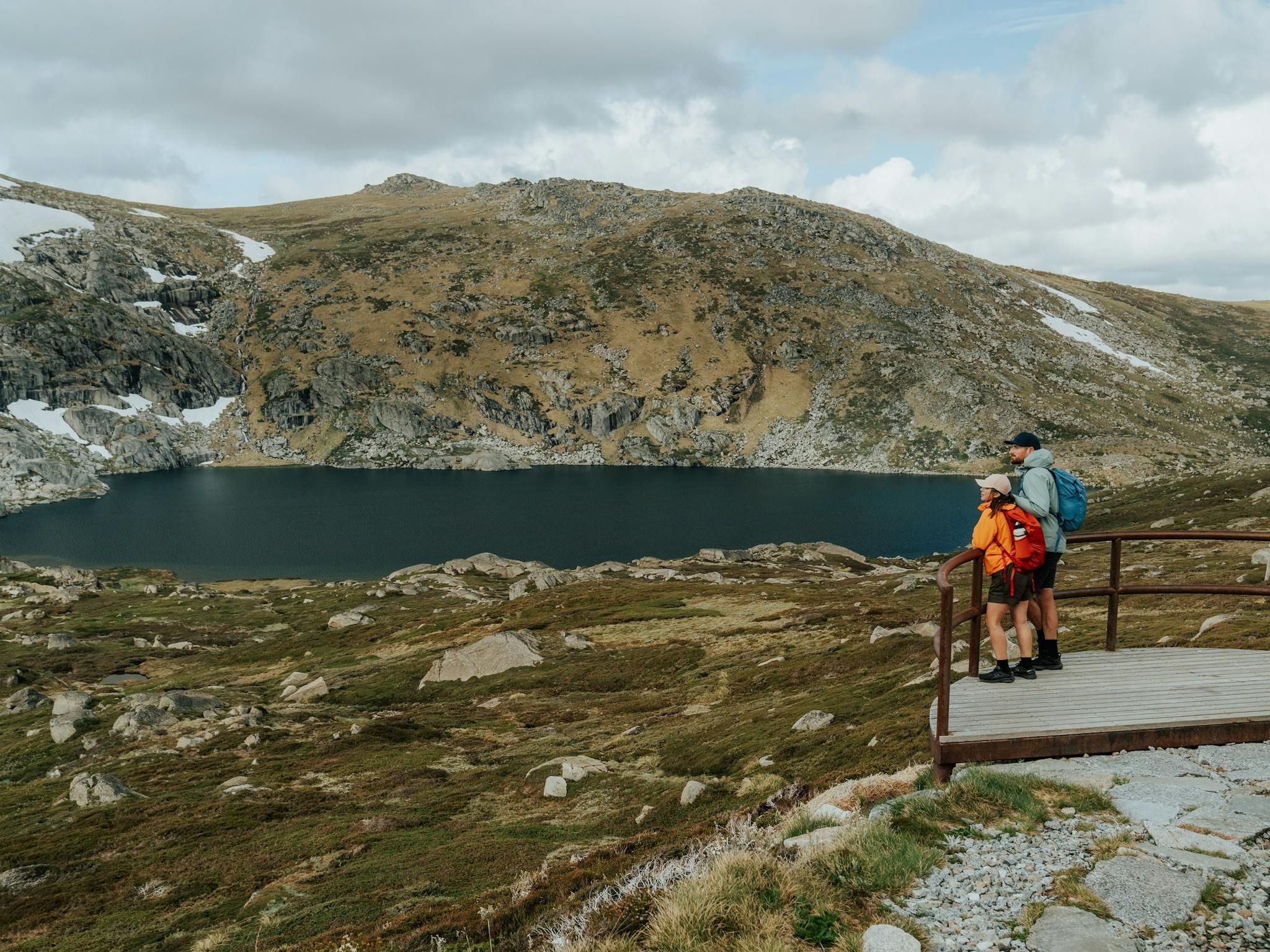 Two walkers take in the veiw from Blue Lake lookout on the Snowies Alpine Walk.