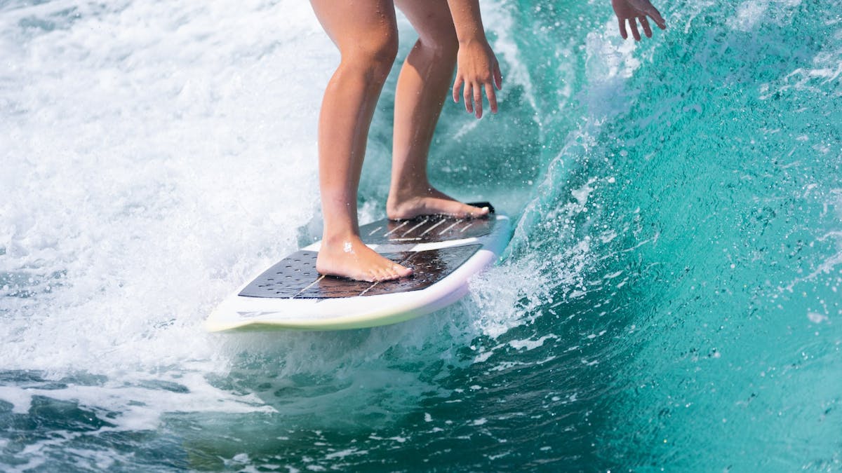 A close up of a wake surfer on a peeling wave. Crystal clear water.