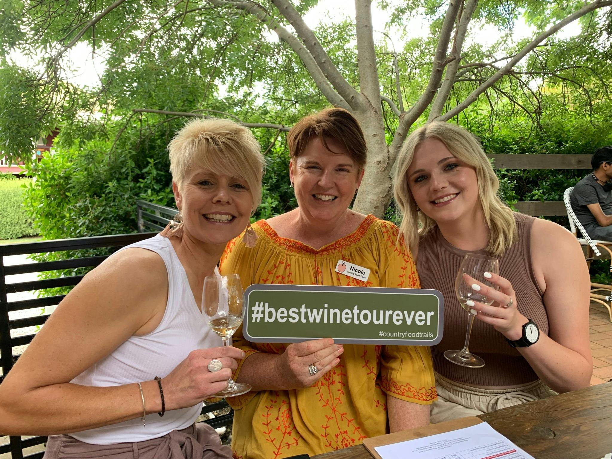 3 ladies drinking wine and holding sign that says 'bestwinetourever'