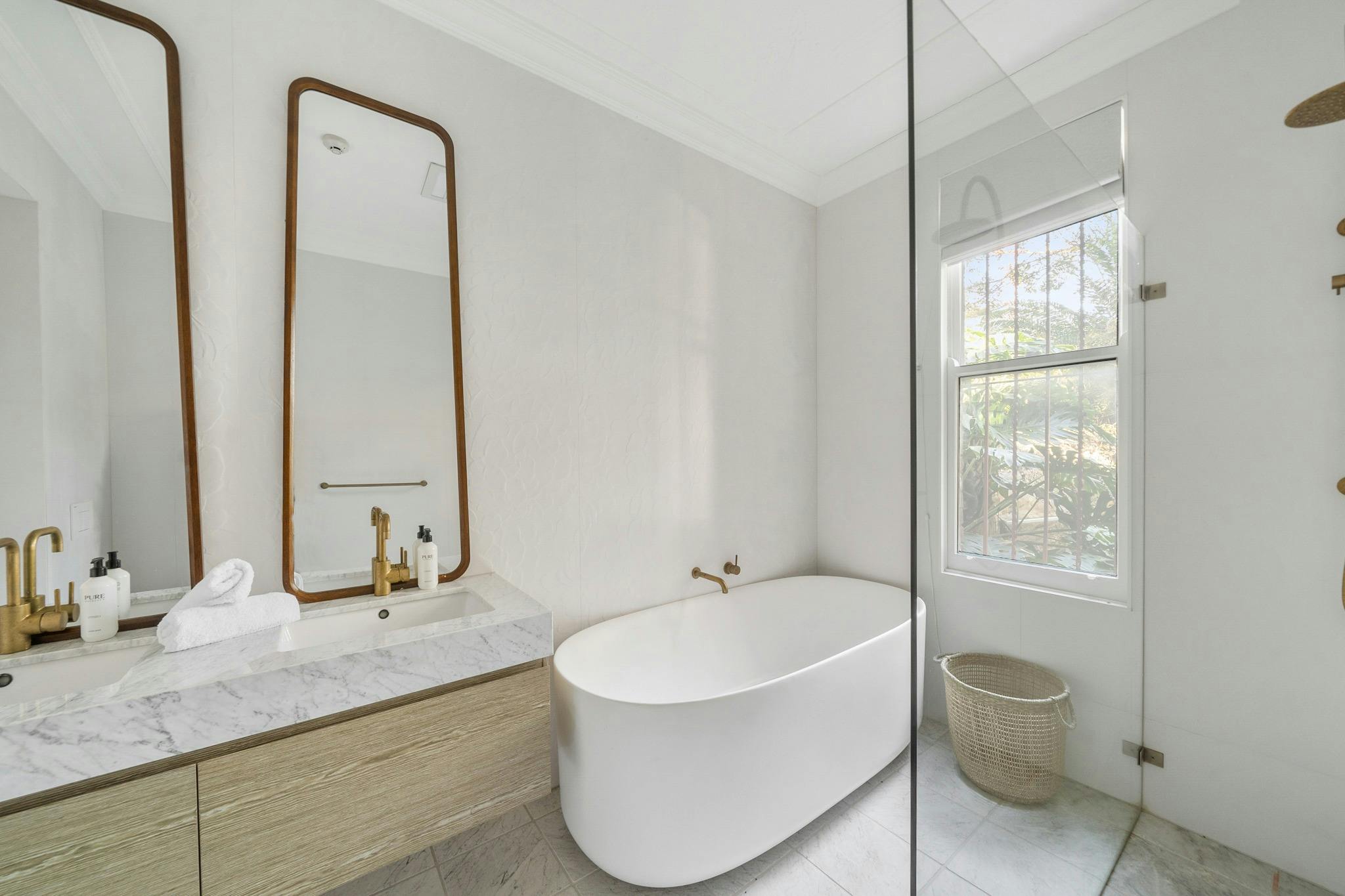 Luxury bathroom with a freestanding tub and golden accents.