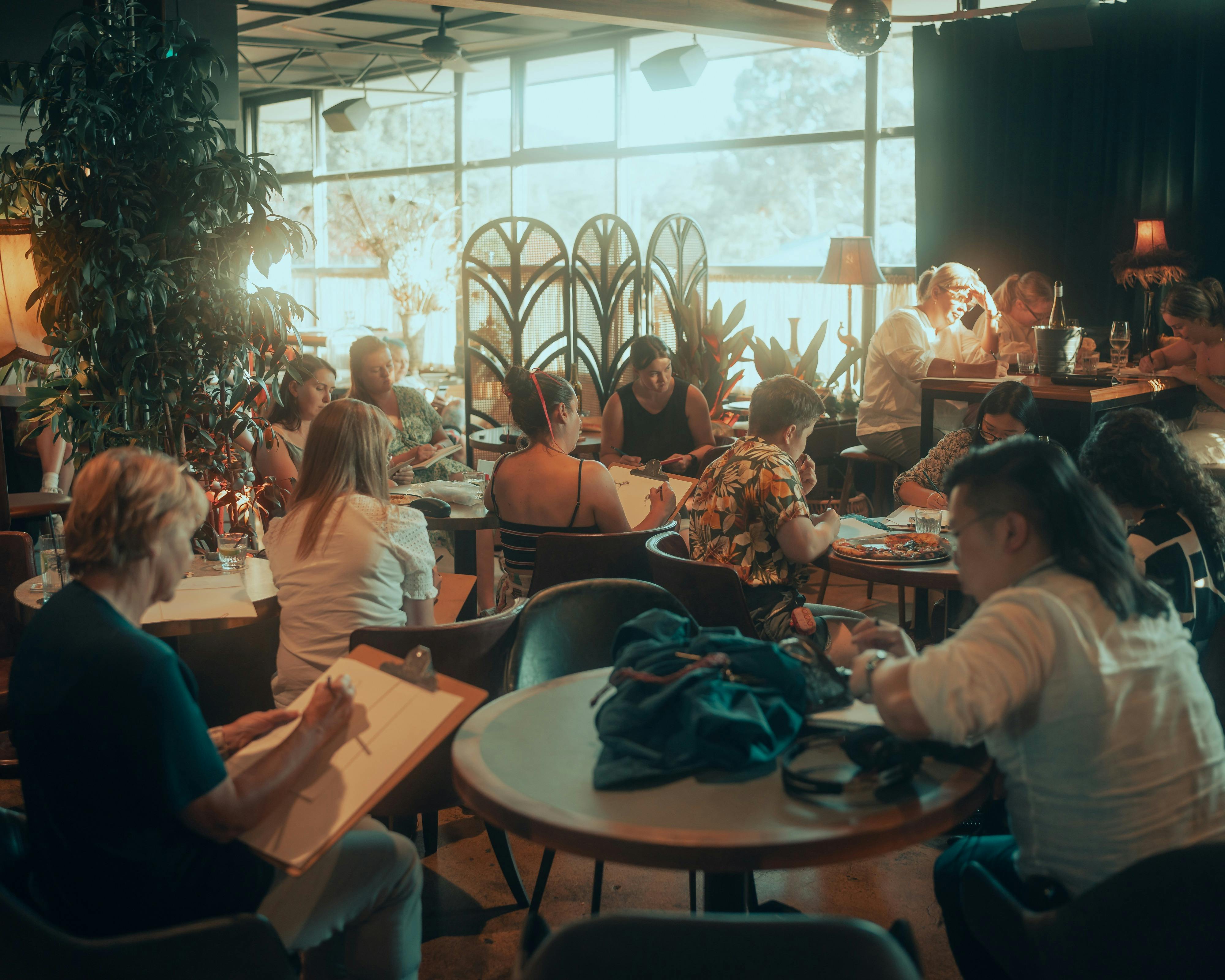 People sitting at tables drawing