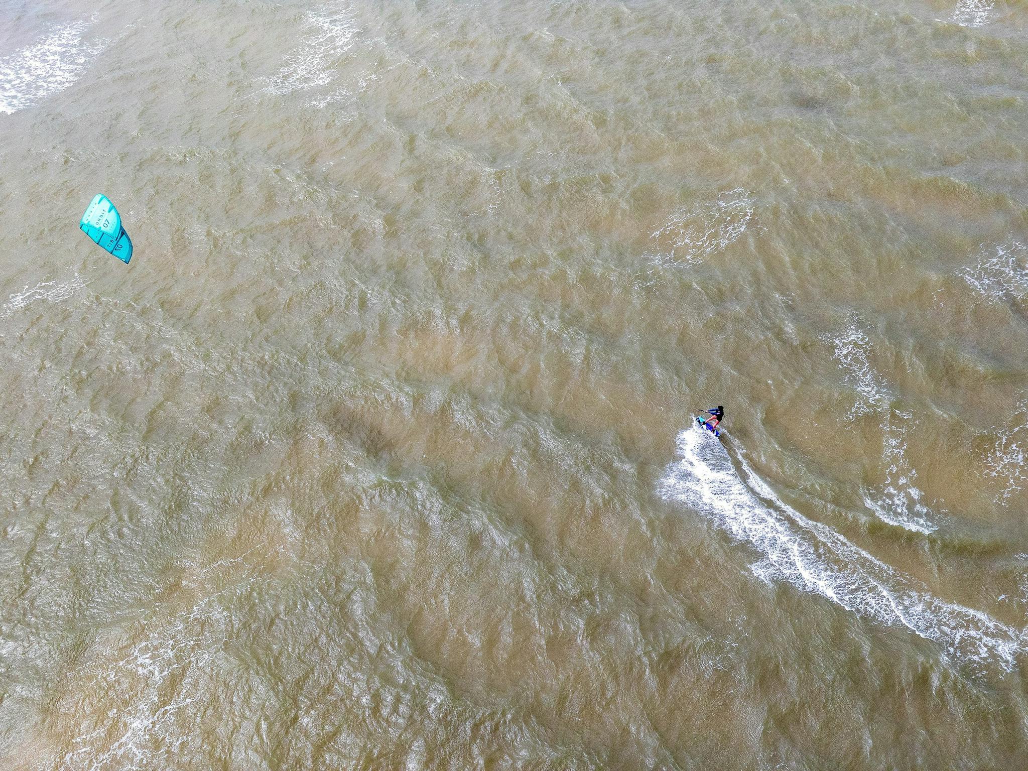 Green kiter riding in shallow water having a great time Green kiter riding in shallow water having a great time
