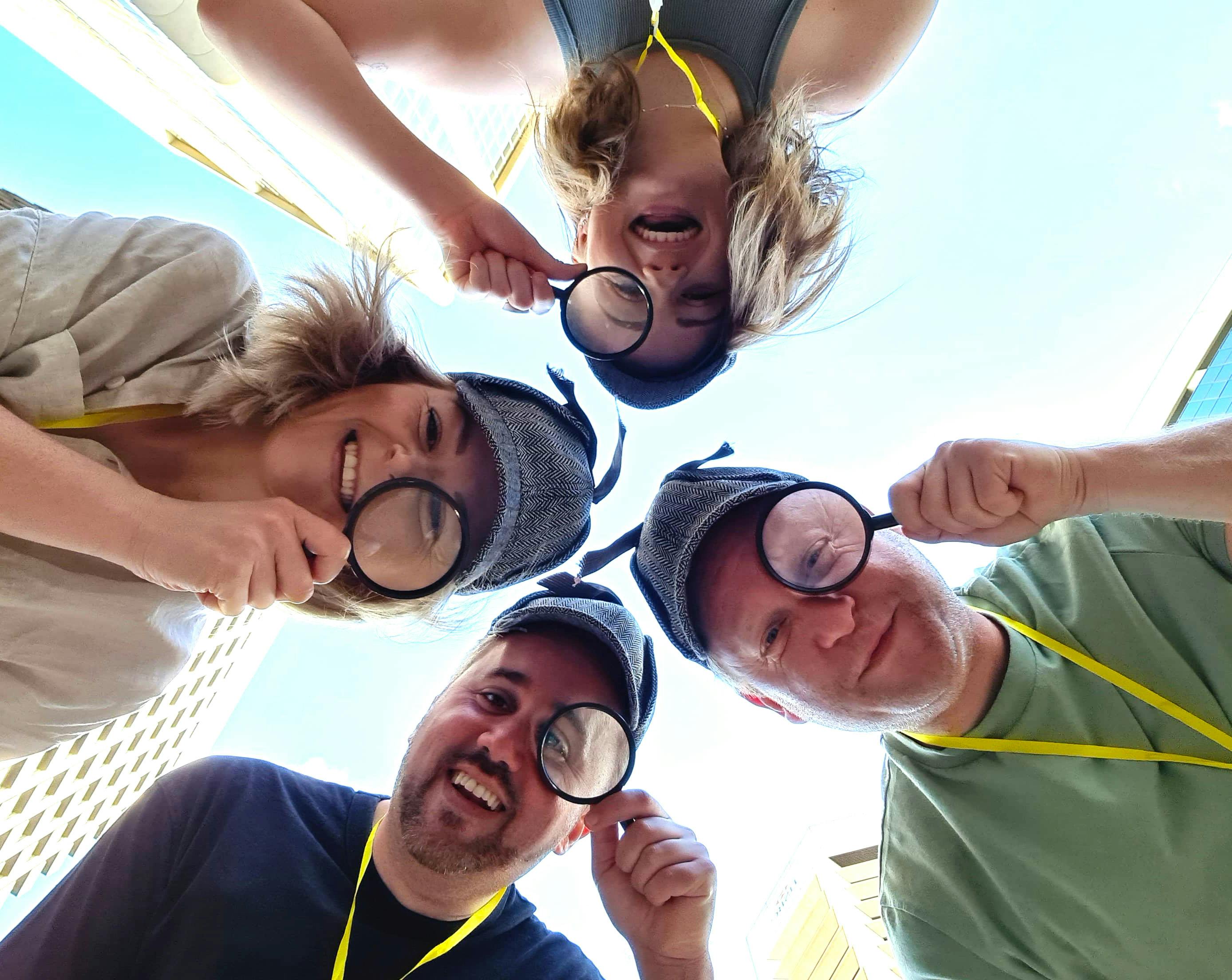 Four people with magnifying glasses