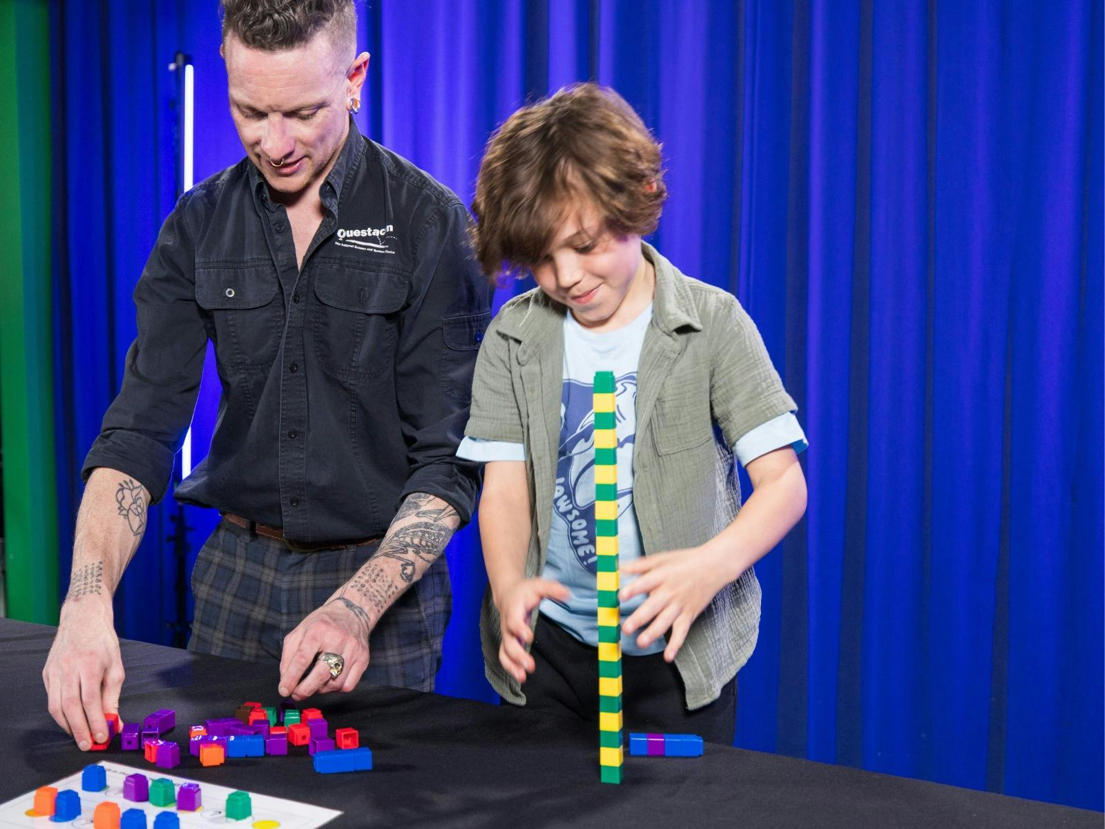 A man and a boy explore patterns using coloured blocks