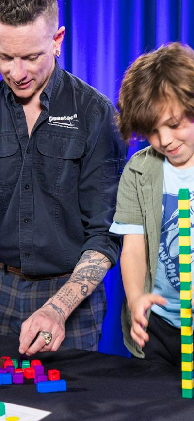 A man and a boy explore patterns using coloured blocks
