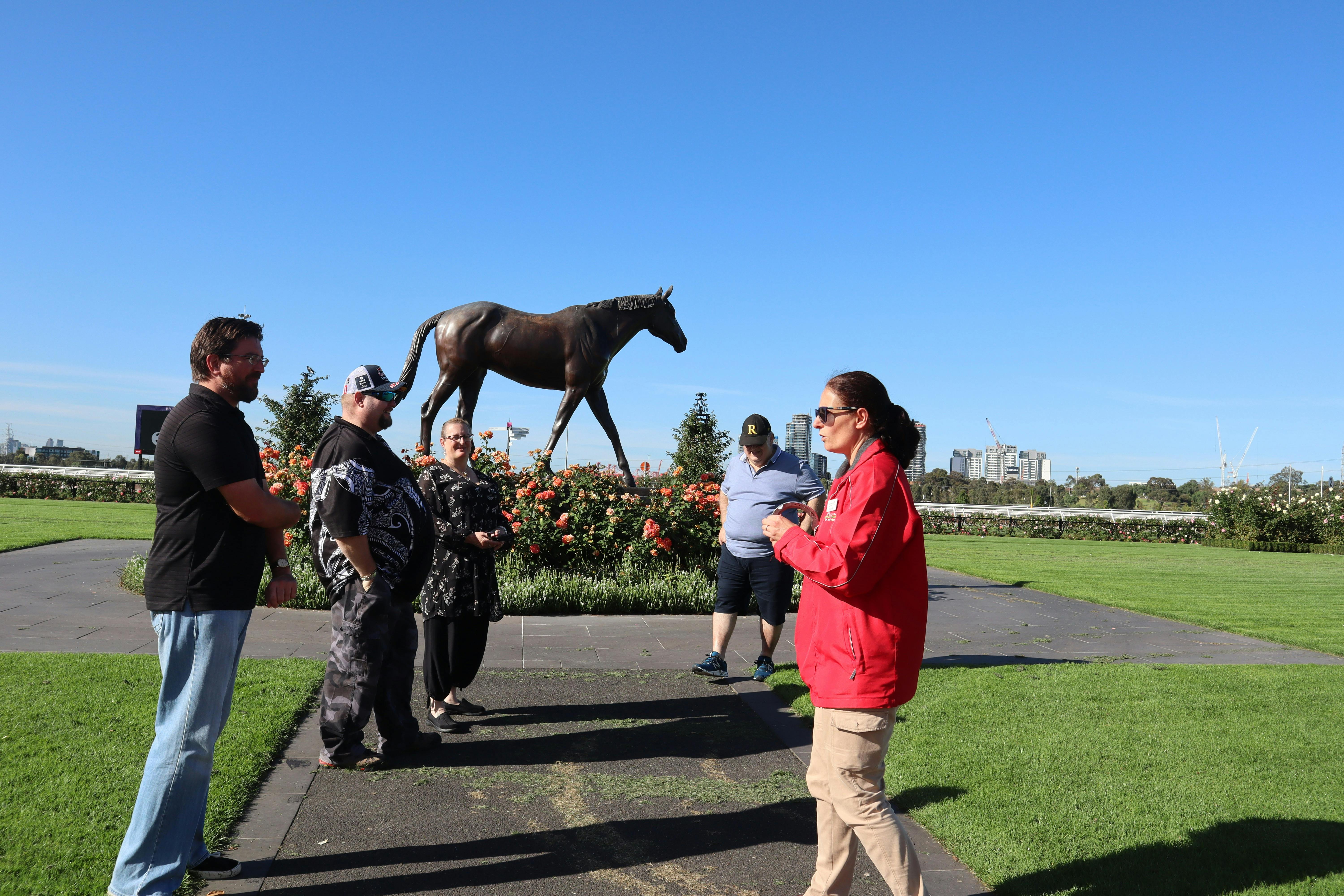 Tour host and guests with Makybe Diva statue at Flemington Racecourse