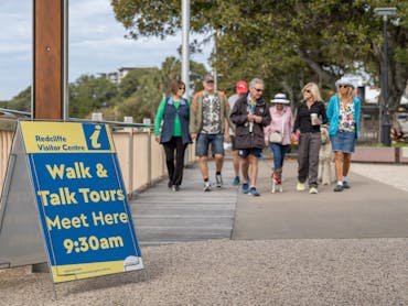 A guide talking while visitors are walking alongside him, near the Redcliffe Jetty. A guide talking while visitors are walking alongside him, near the Redcliffe Jetty.