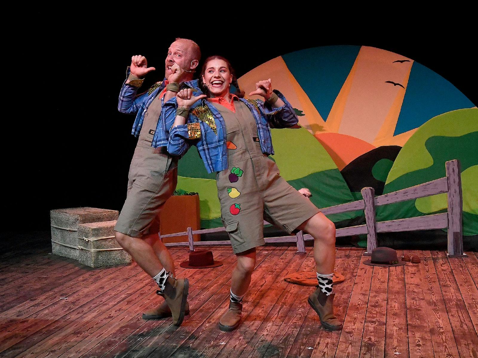 Two children's performers leaning into each others shoulders on stage