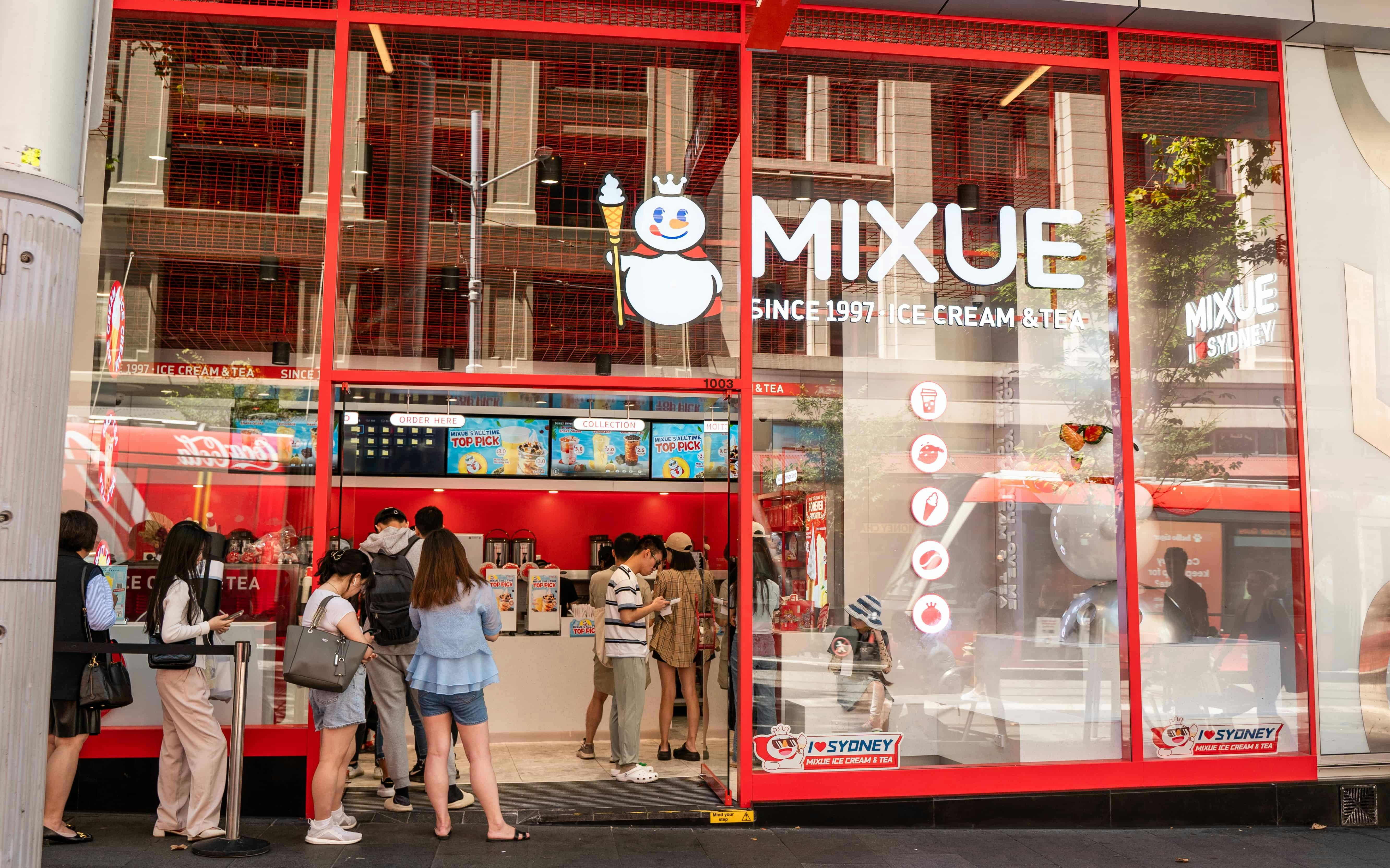 Foto von Mixue Shopfront mit Leuten, die Schlange stehen und Tee und Eis bestellen