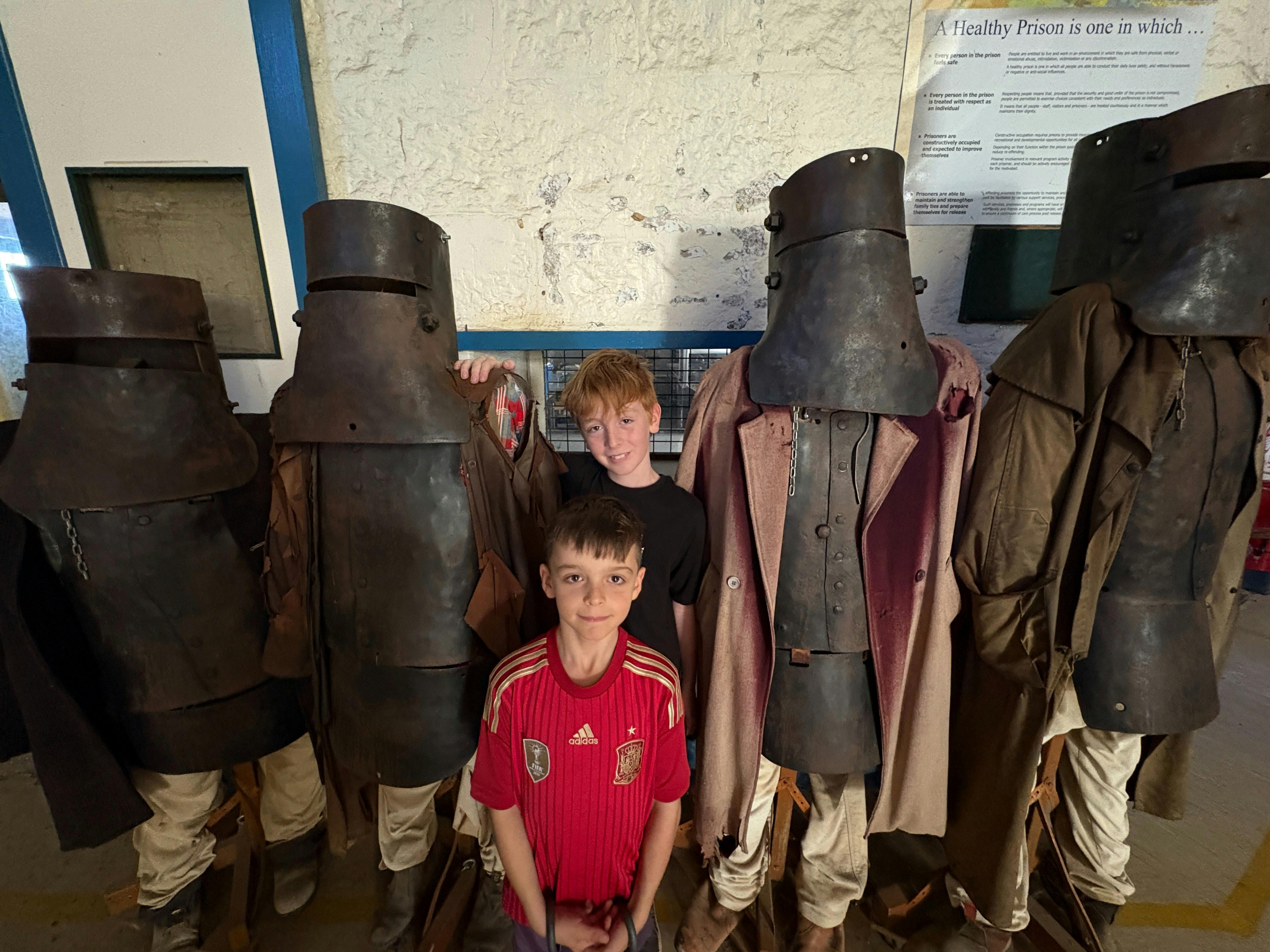 Children standing next to replicas of the Kelly Gang armour.