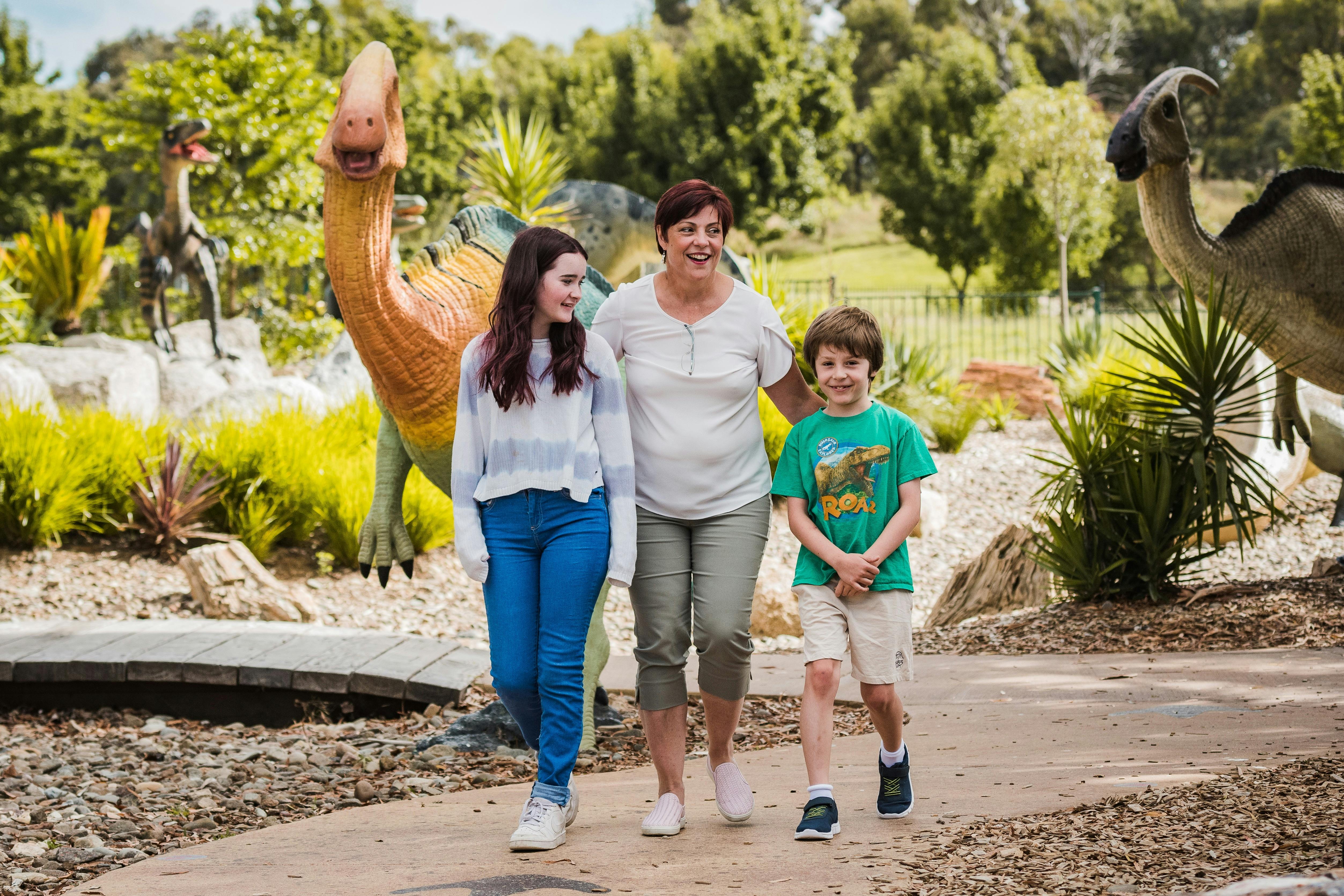 Teenage girl, Auntie and little boy strolling in the Dinosaur Garden