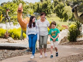 Teenage girl, Auntie and little boy strolling in the Dinosaur Garden