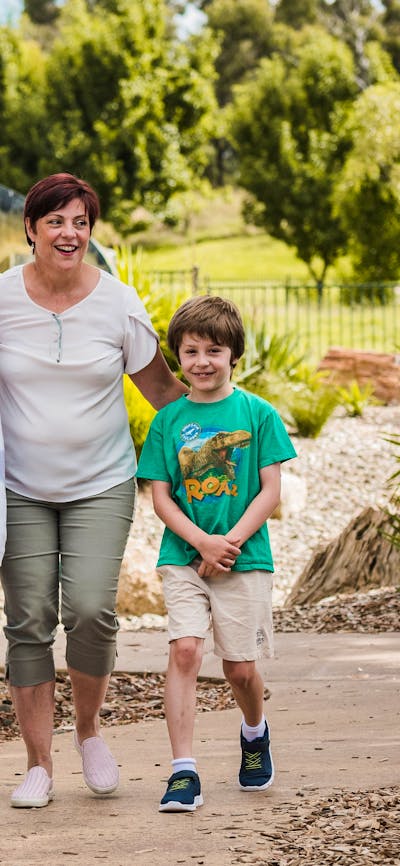 Teenage girl, Auntie and little boy strolling in the Dinosaur Garden