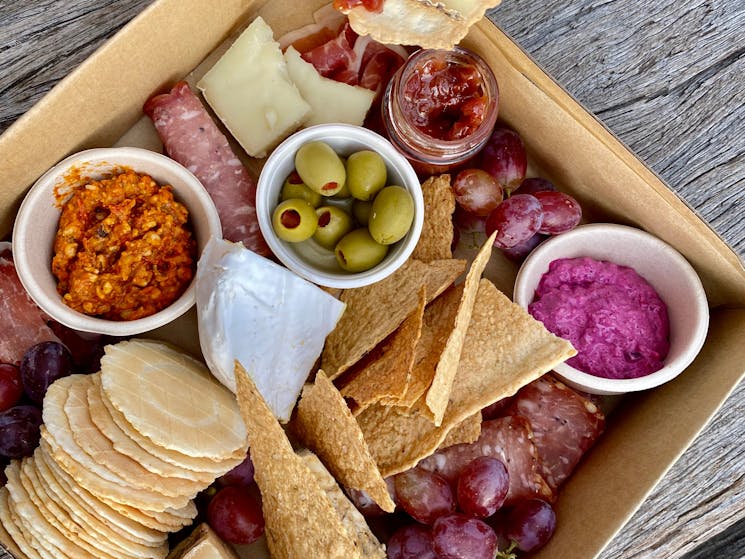 Grazing box full of savoury treats, like meats, cheeses and dips, made ready to go to enjoy anywhere