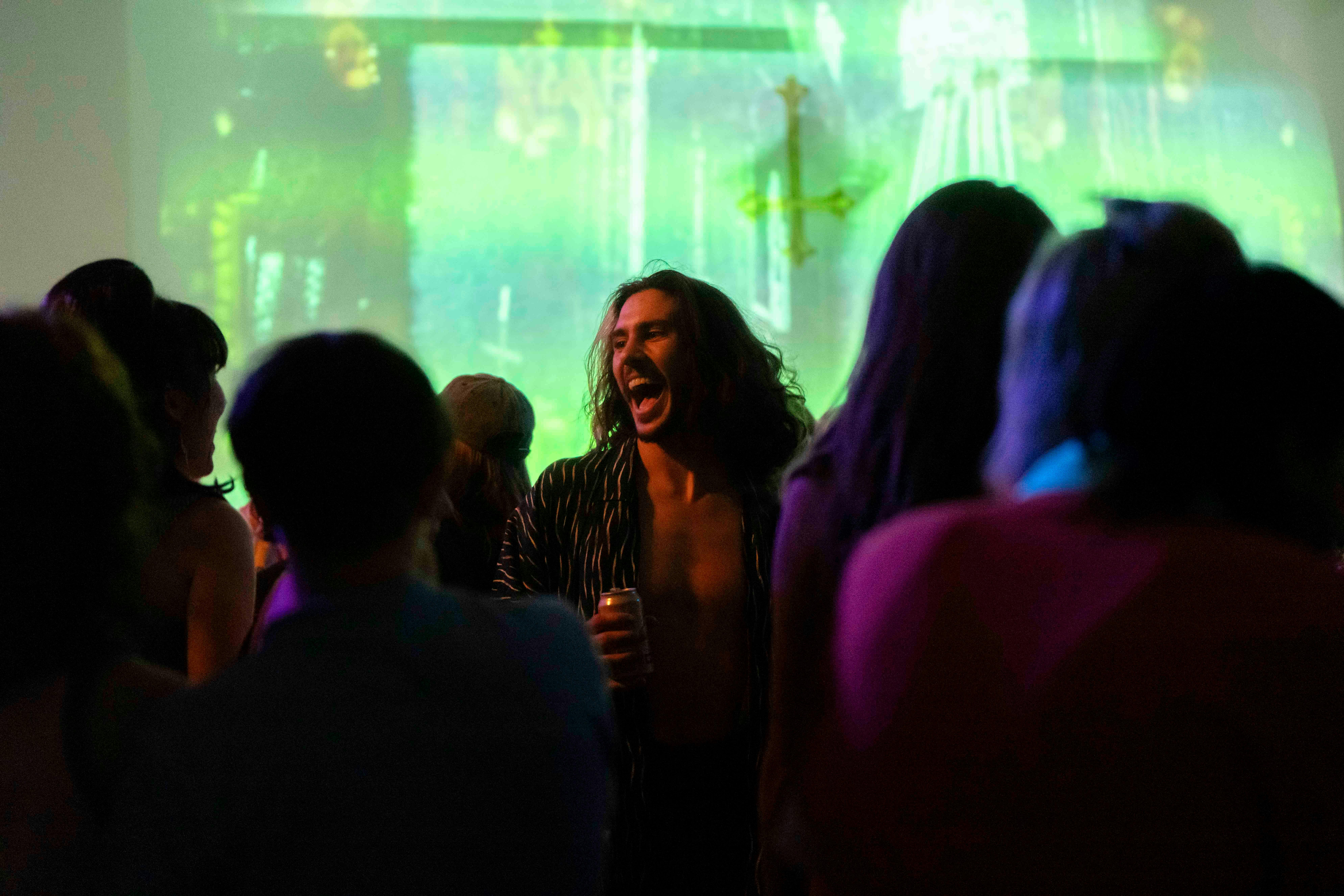 Audience dancing, centering on male laughing in the middle of the crowd