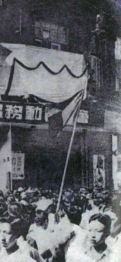 A sepia photograph of a crowd in Shanghai at the Tianchan Theatre