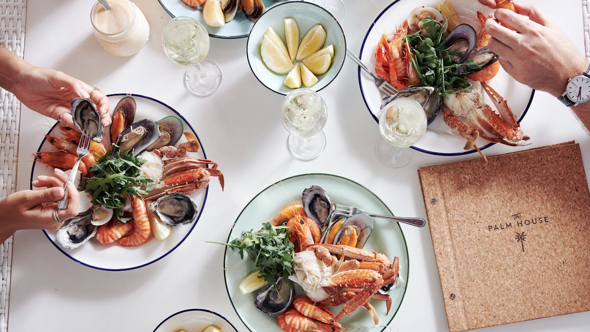 Various plates of seafood dishes on a white table