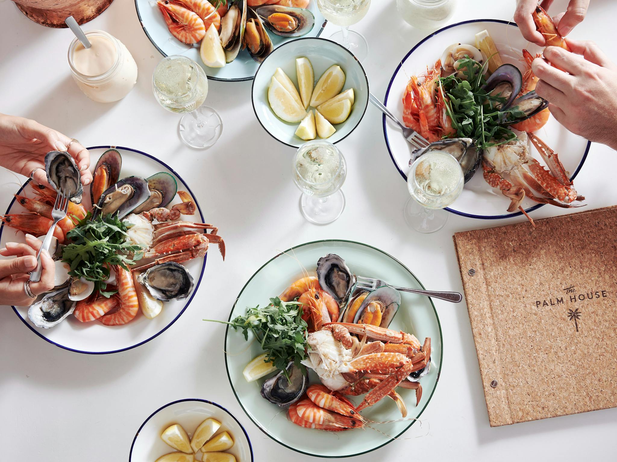 Various plates of seafood dishes on a white table Various plates of seafood dishes on a white table