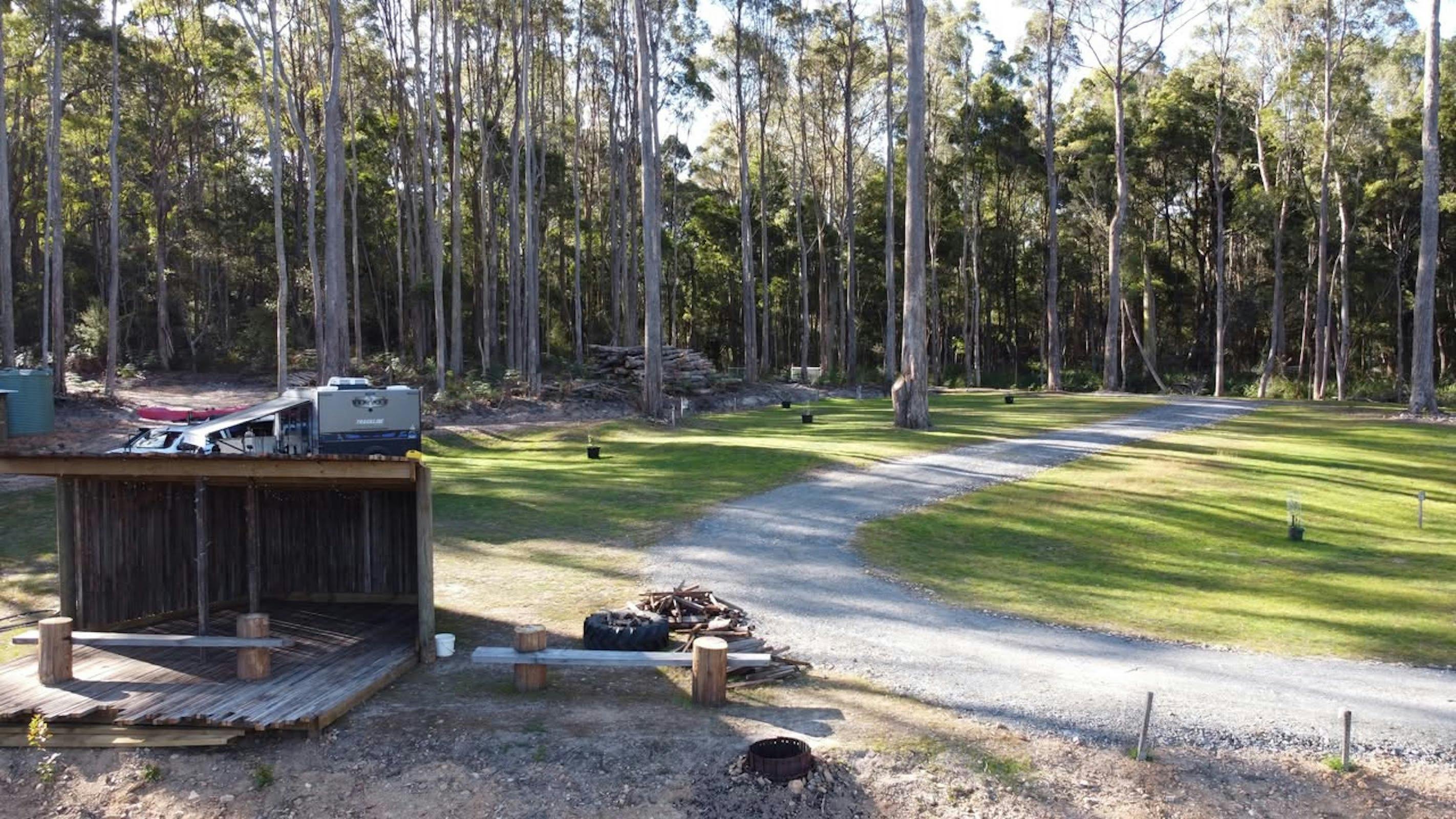 A camp shelter in front of a road in between camp sites with Recreational Vehicles in the backgorund