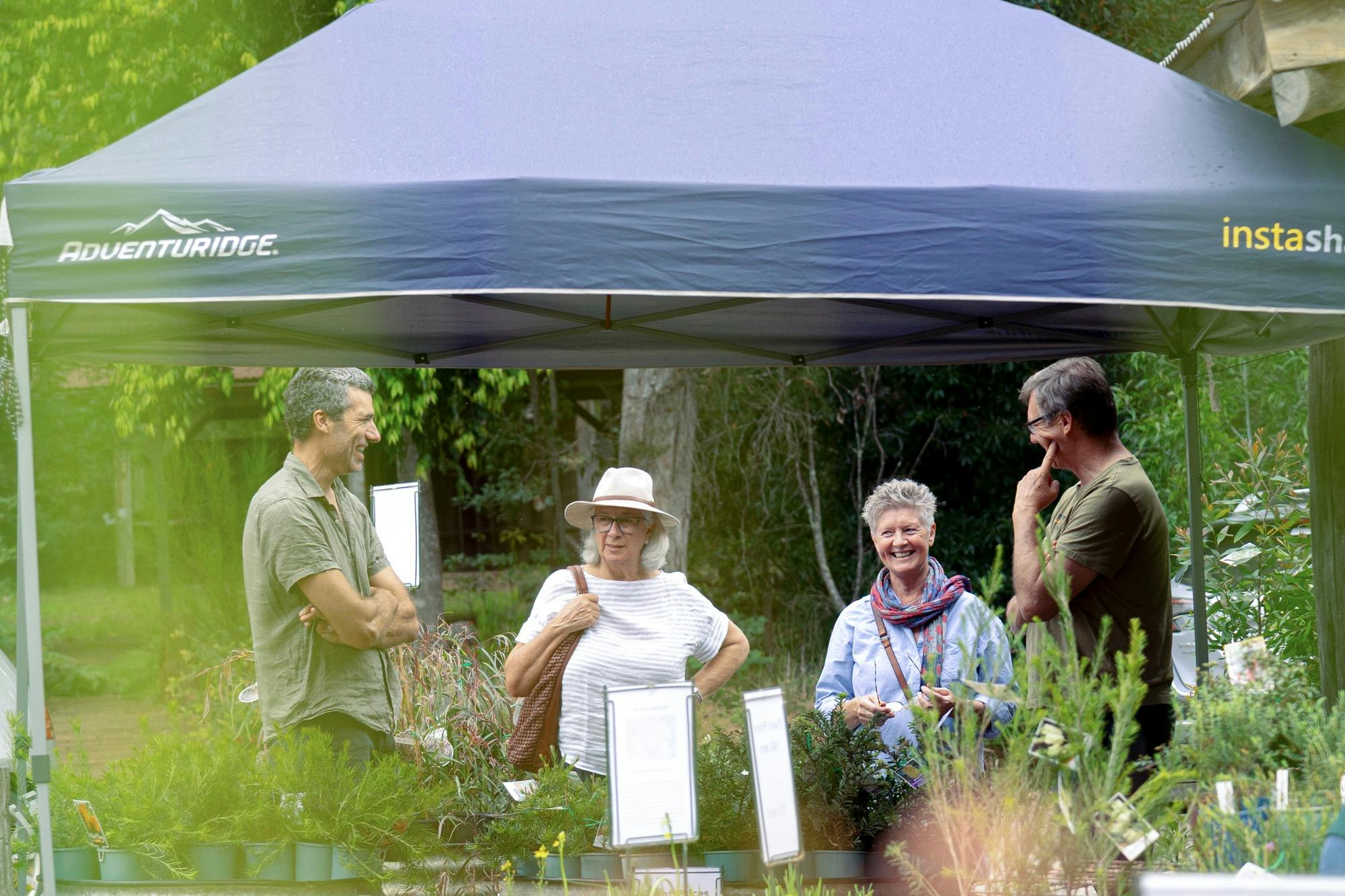 A group of people browsing vibrant native plants at the Kangarutha Farm open day.