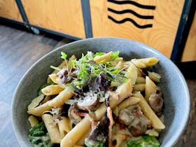 Photo of a bowl of creamy bacon and mushroom pasta