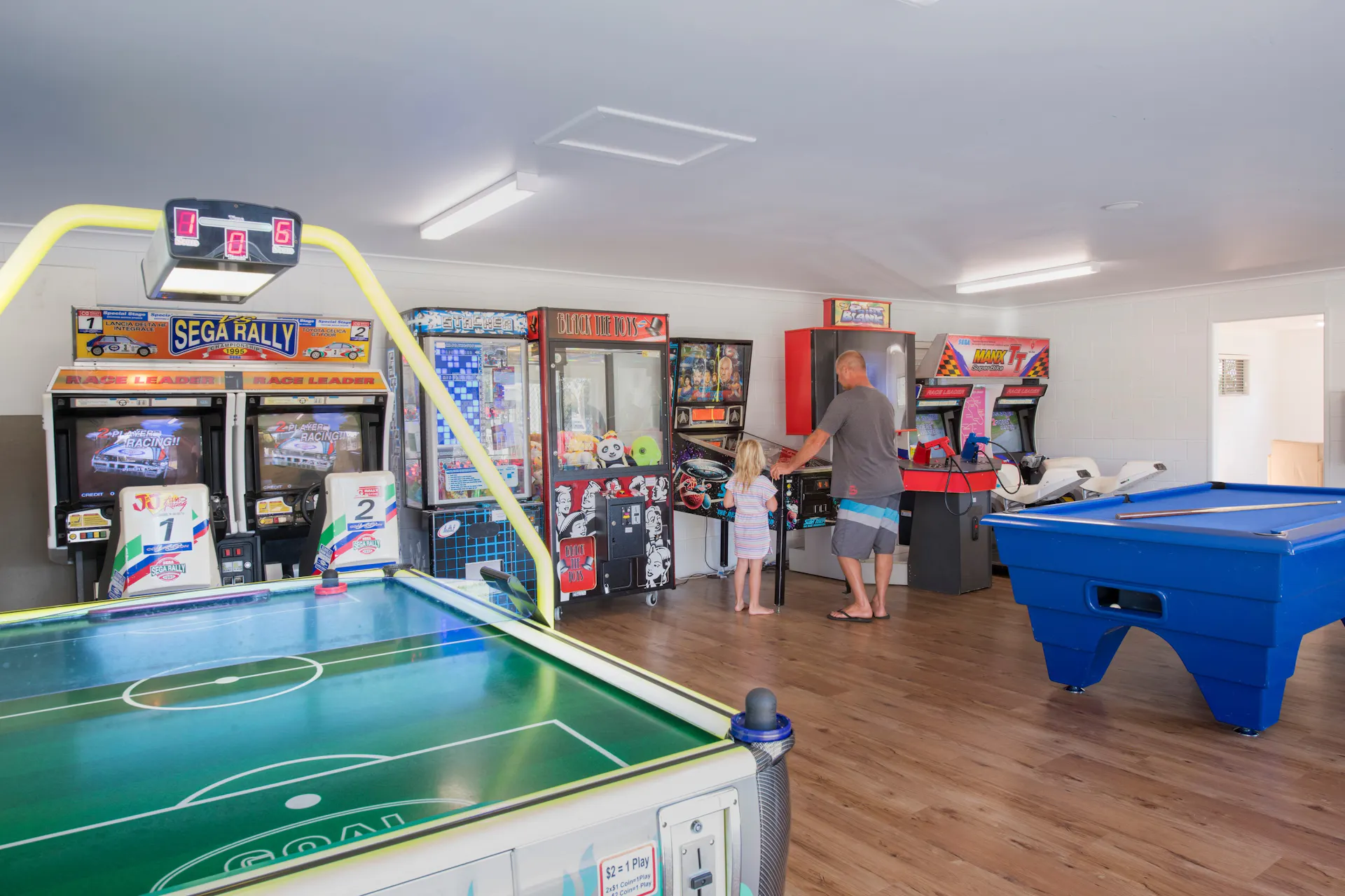Image of Dicky Beach Holiday Park games room with father and daughter playing pinball