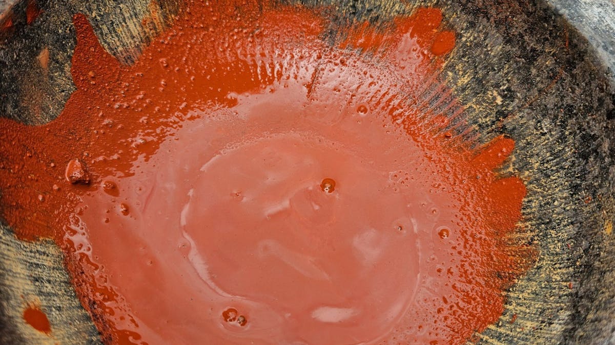 Red Ochre cruched and mixed with water to provide a deep earth colour