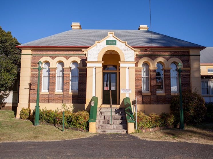 Image is a old building with steps, arched windows in the sun