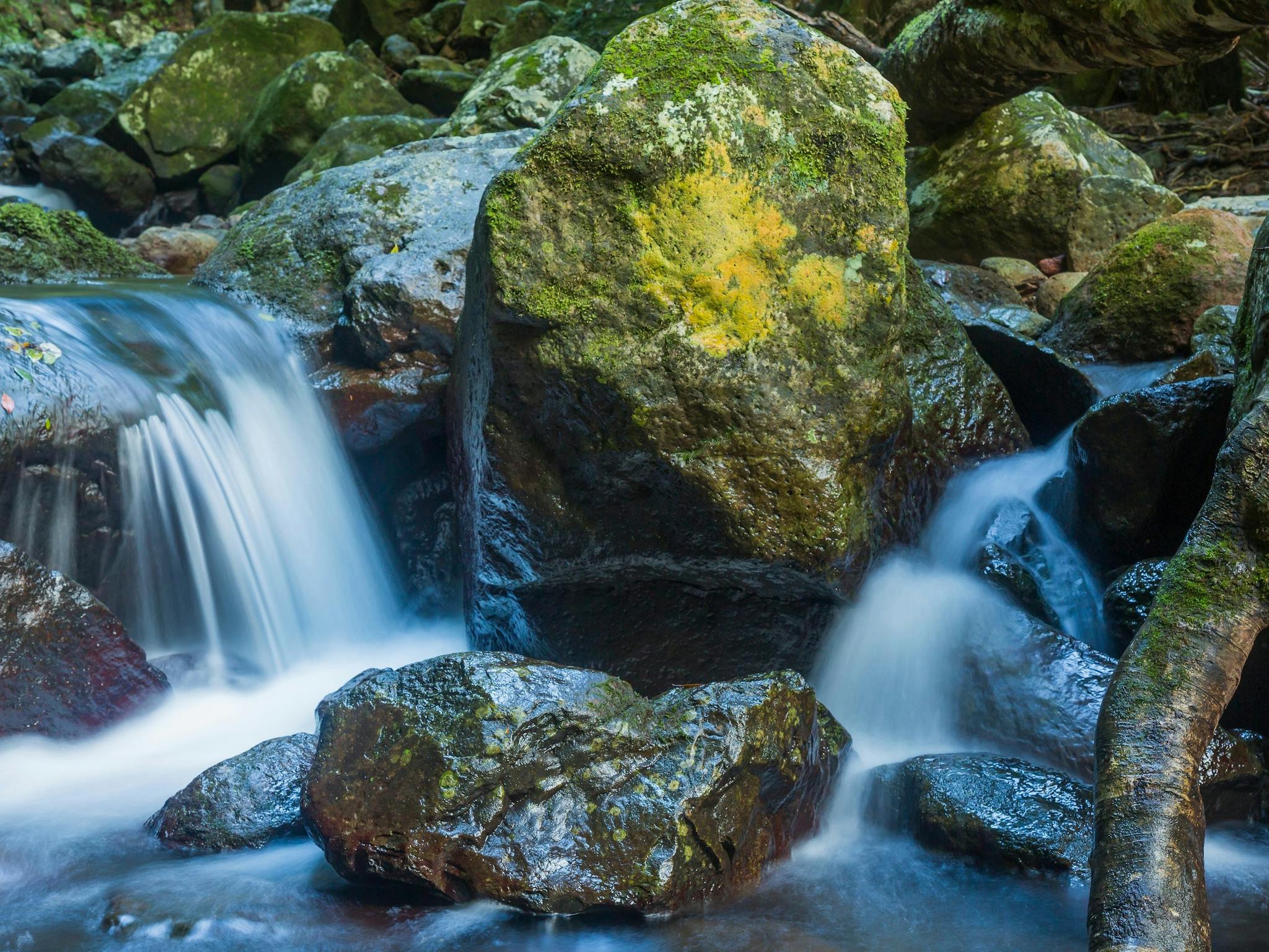 White water cascades over rocks into a rock pool. White water cascades over rocks into a rock pool.