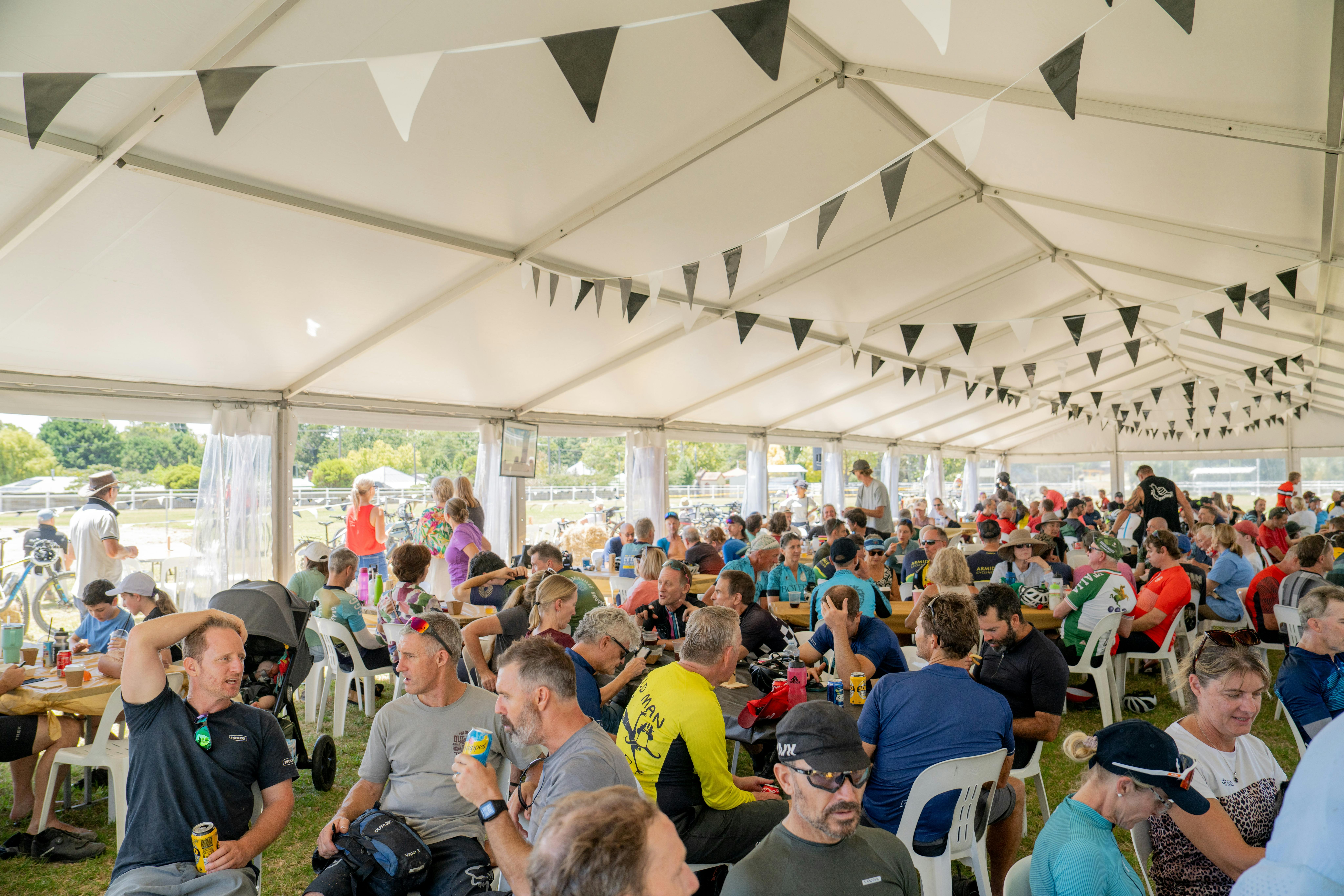 Riders relax under a marquee with food and drinks at the Race Village.