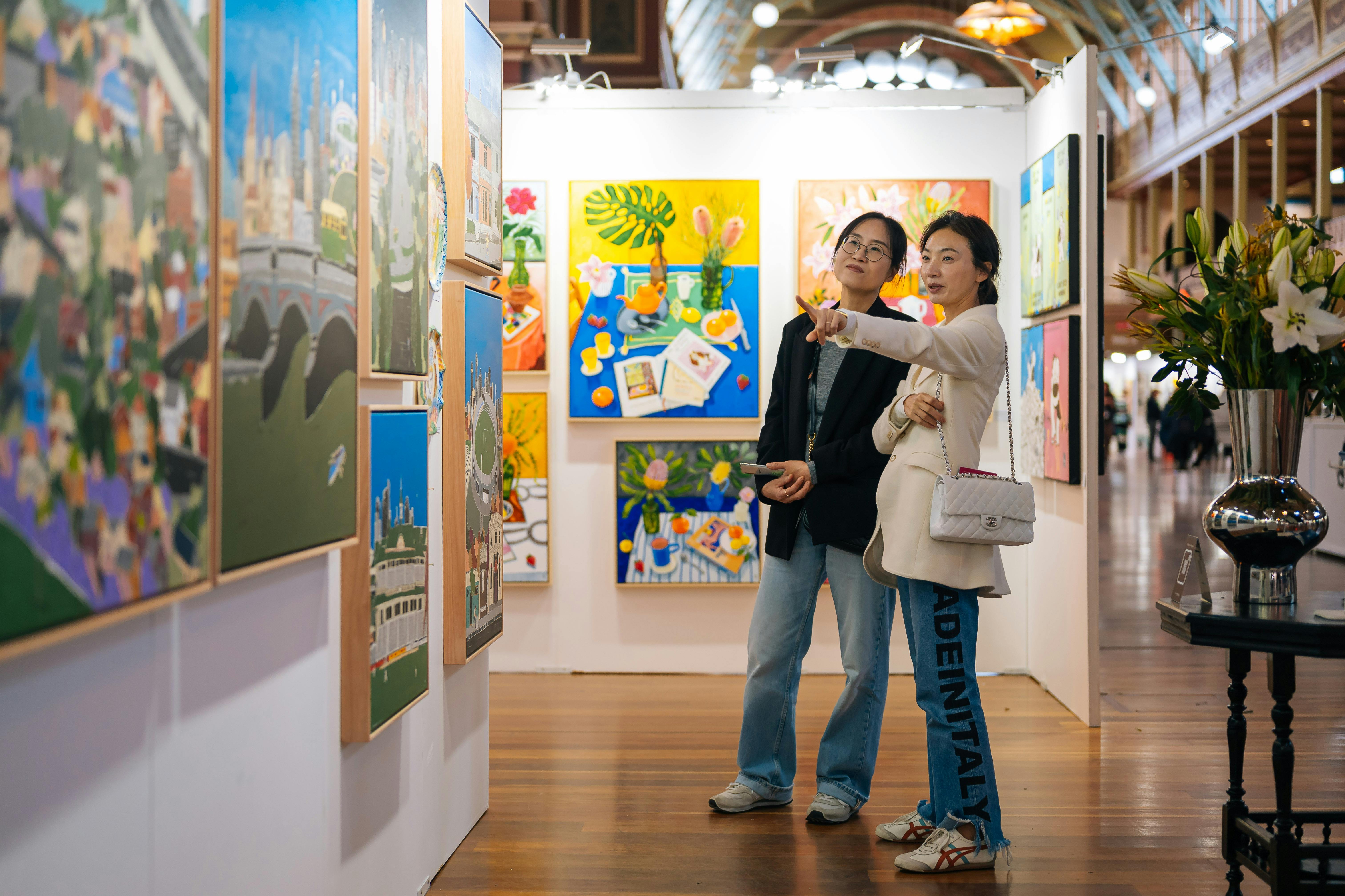 Image of two visitors pointing at art