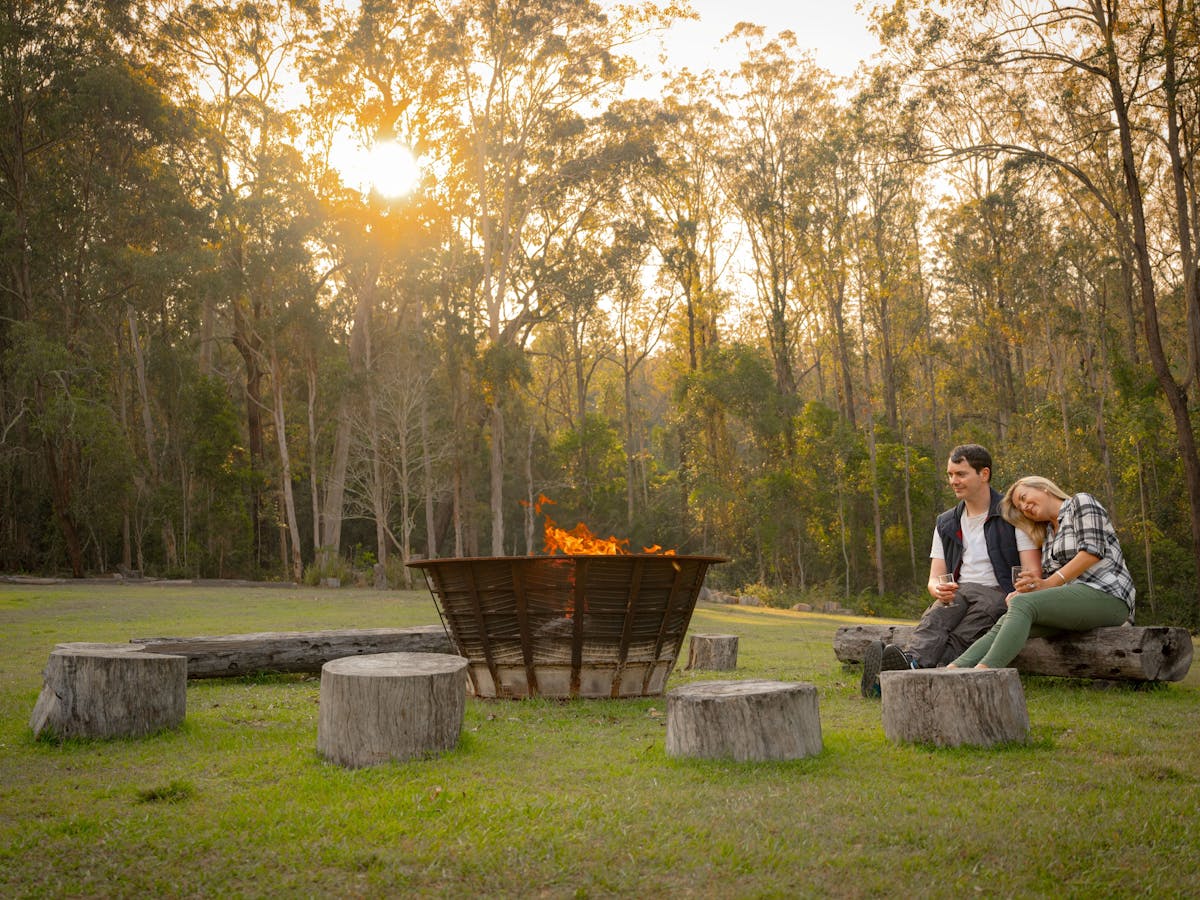 Couple sitting beside campfire in the Jimna bushland